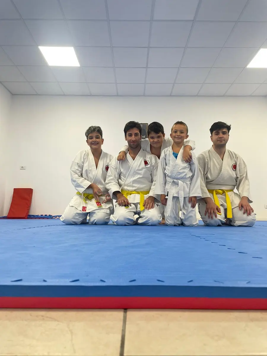 Allievi giovani in karategi insieme agli istruttori sul tatami