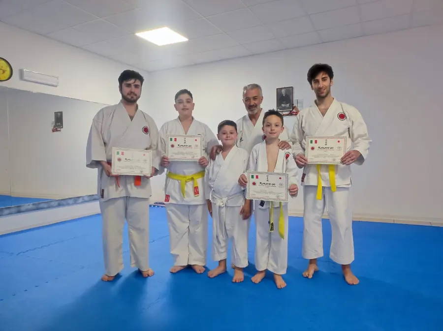 Gruppo di allievi con gli attestati insieme al maestro dopo un esame